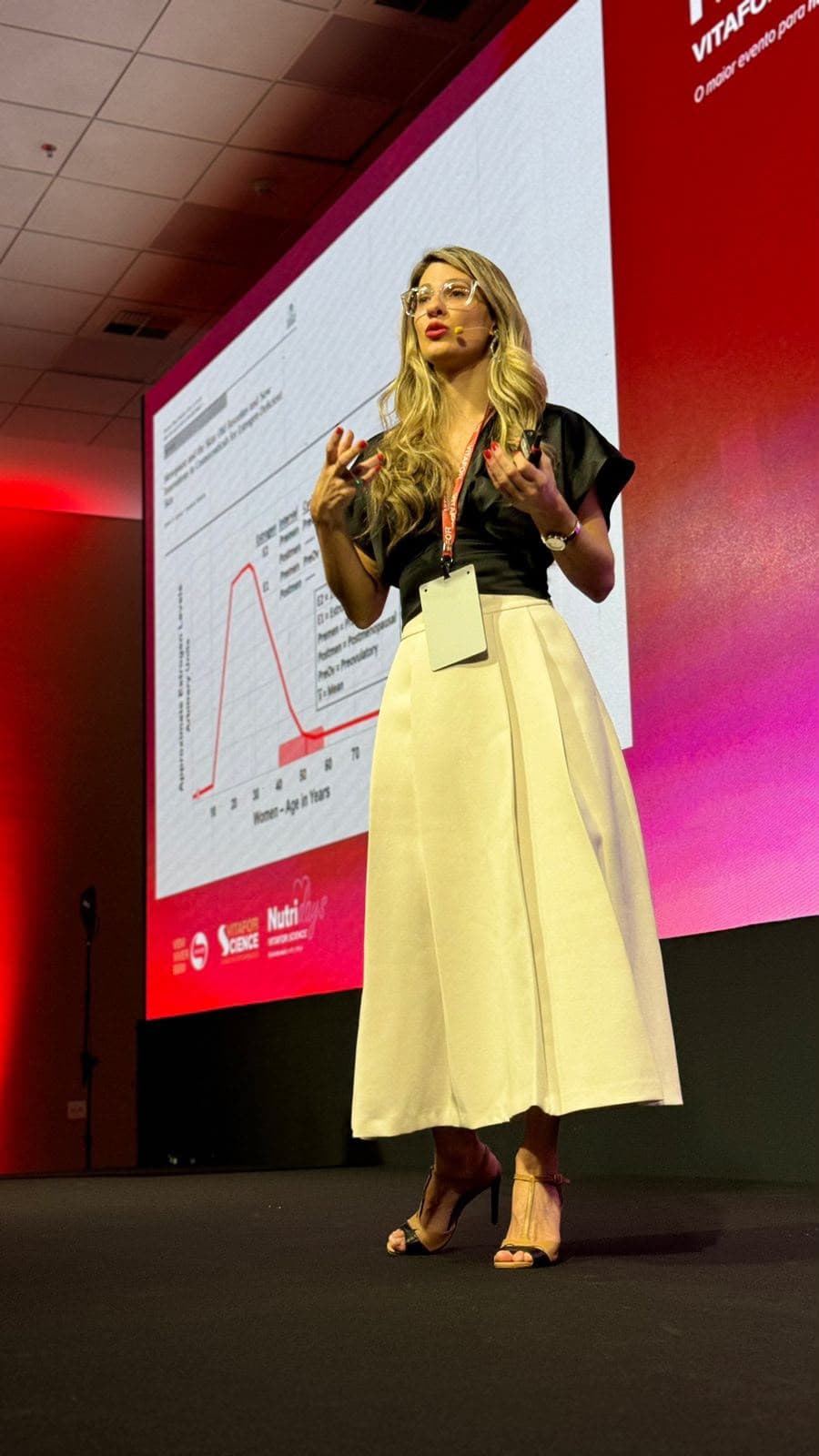 Luisa Wolpe no palco do Vitafor Science apresentando dados sobre estrogênio e saúde da mulher